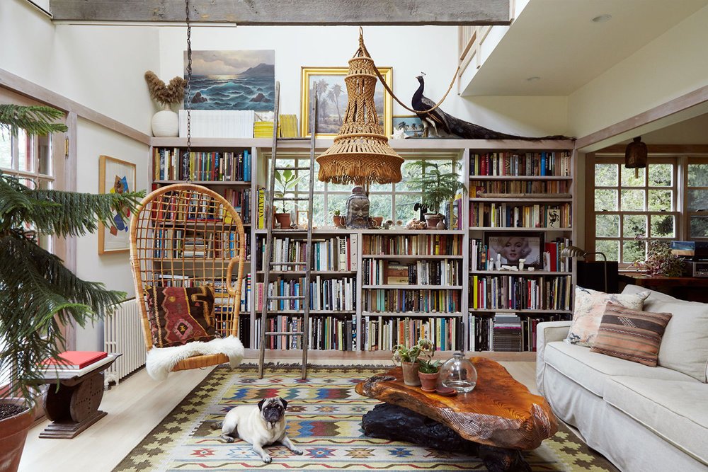 Vintage rug, adorable pug, and a heckton of books in upstate New York. Image from  Lonny